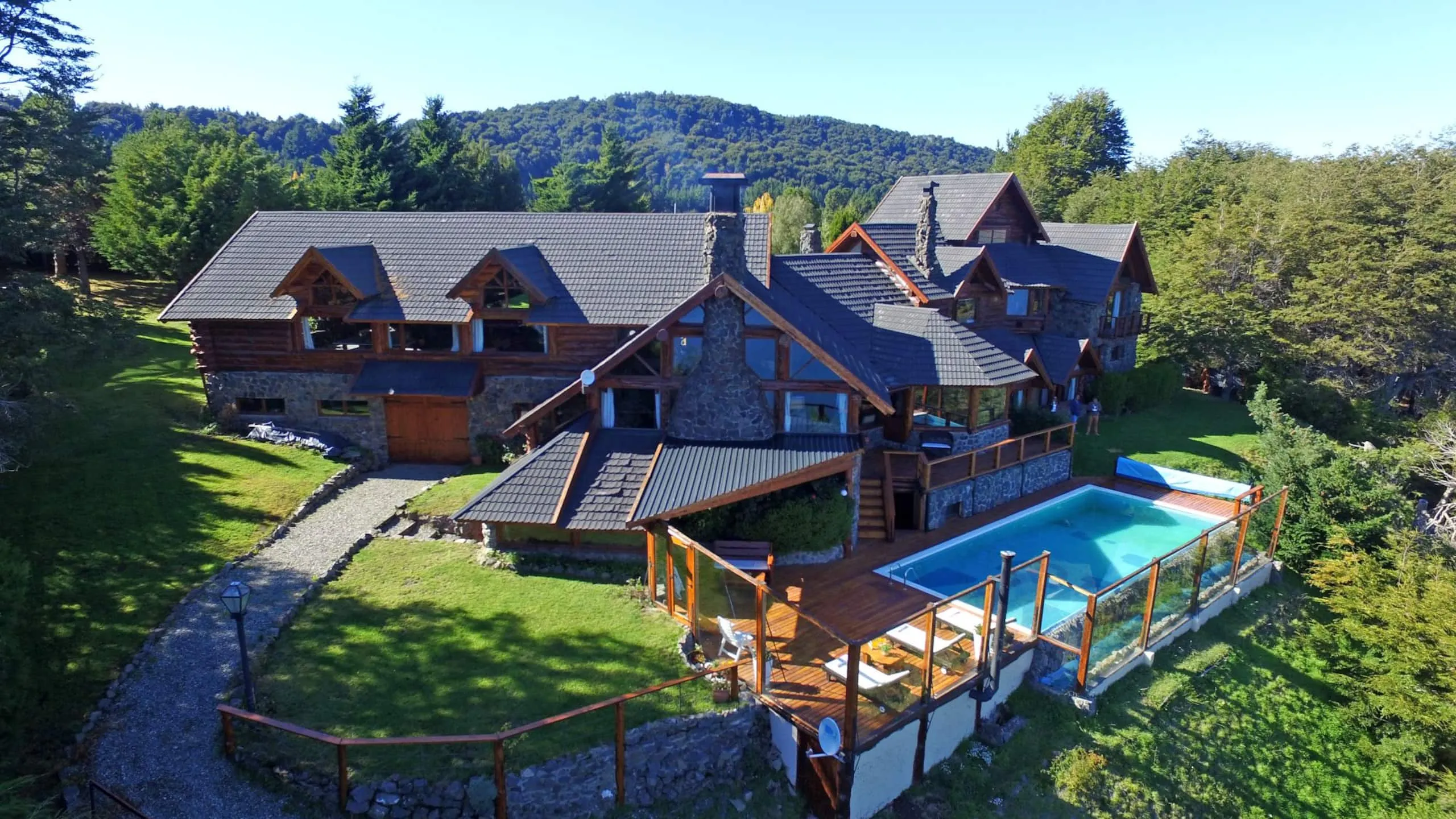 Vista aérea de la casa de troncos con la piscina exterior y el deck