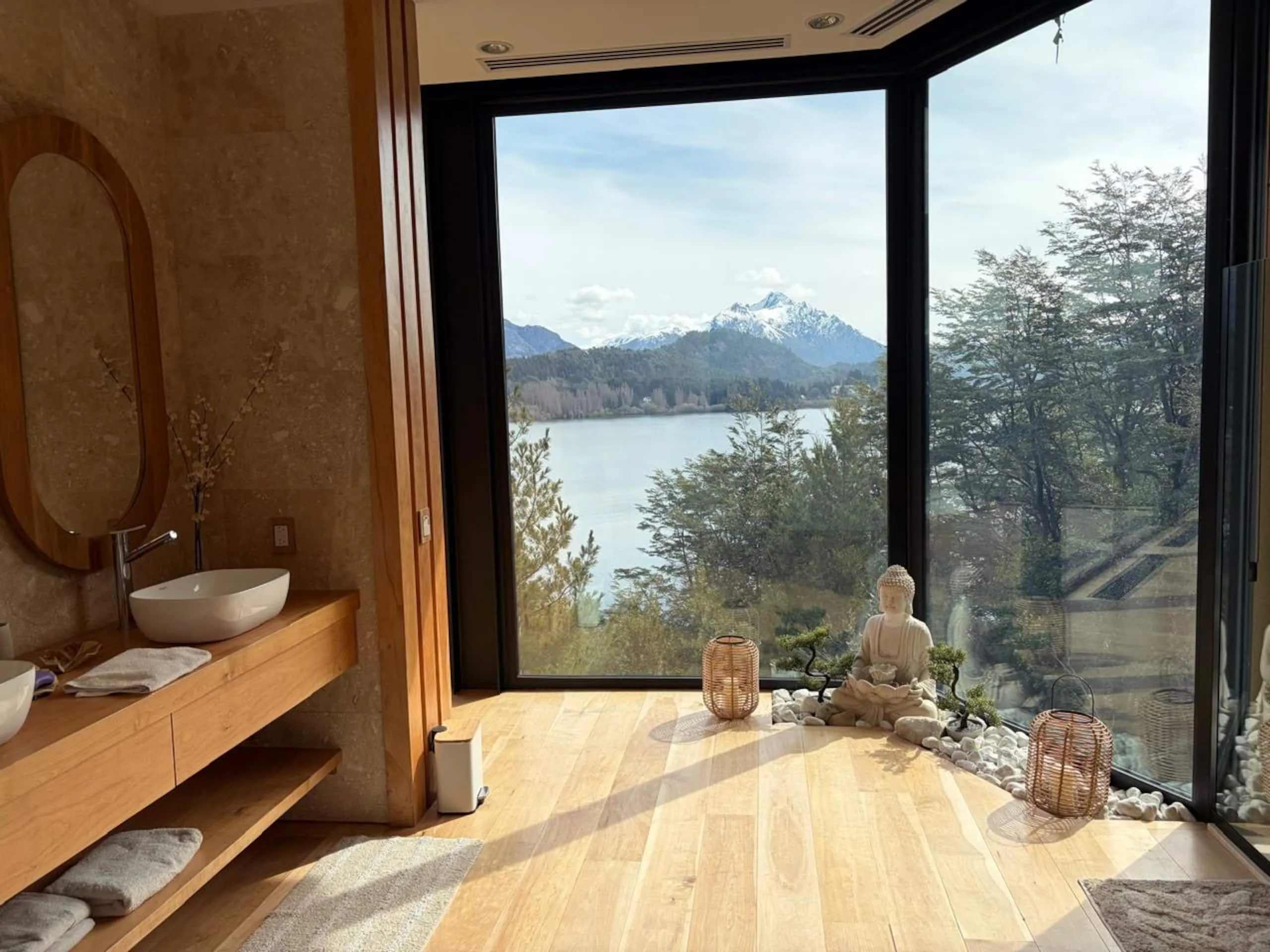 Rincón del baño con ventanal al lago y piso de madera