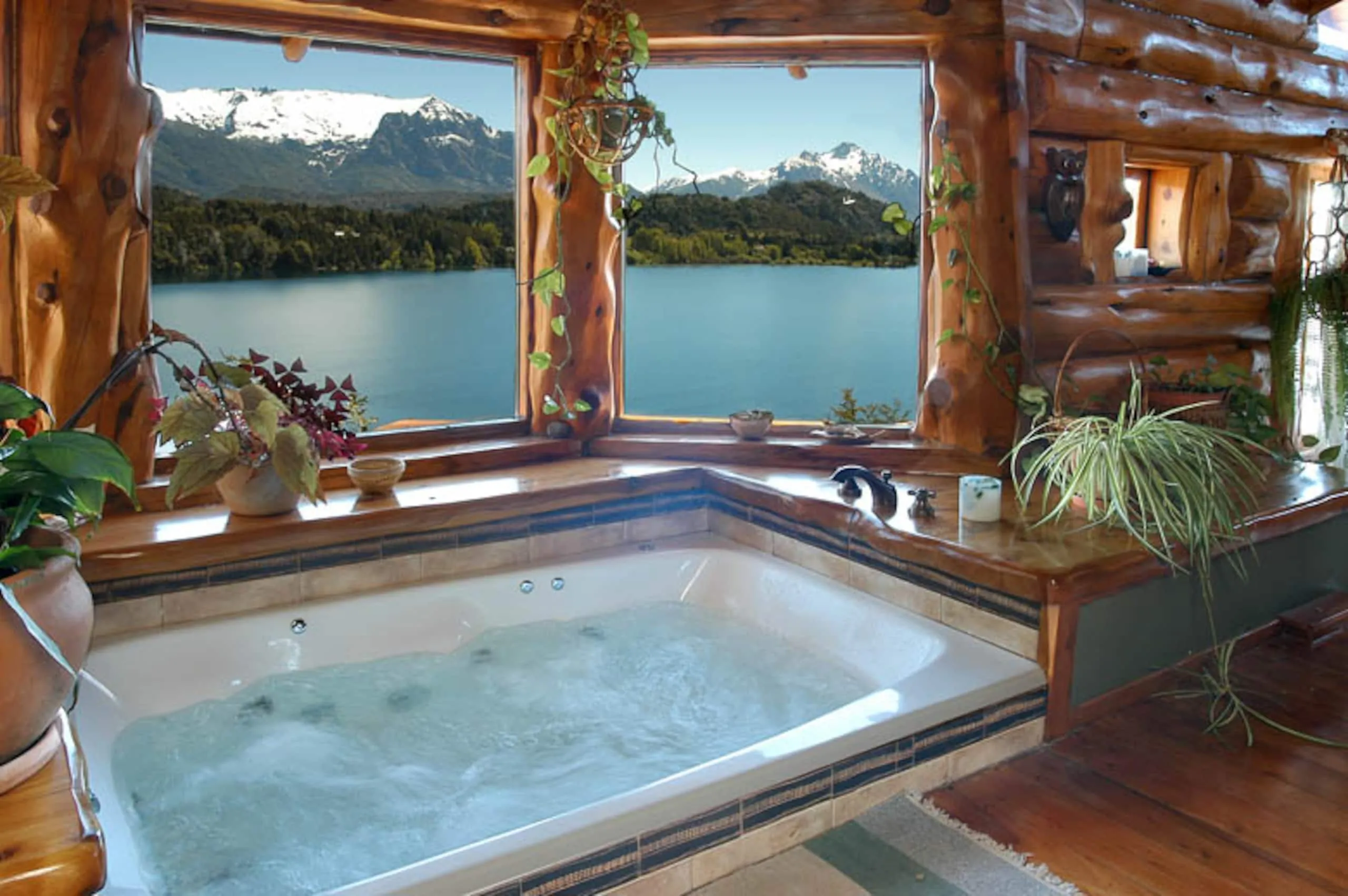 Hidromasaje interior frente a una ventana con vista al lago y la cordillera